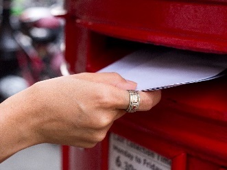 A person posting their ballot papers. 